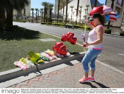Oct 3, 2017 - Las Vegas, Nevada, U.S. - Marion Wilcox, of Hayden, Idaho, leaves balloons at a makeshift memorial on the Las Vegas Strip Tuesday. Wilcox was staying in a nearby hotel when a mass shooting occurred late Sunday evening at an adjacent music festival. Las Vegas U.S. - ZUMAc98_ 20171003_jlr_c98_007 Copyright: xRondaxChurchillx