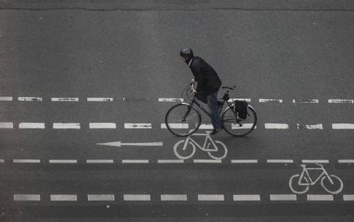 Ein Radfahrer mit Helm faehrt ueber eine Kreuzung auf dem Radstreifen. Berlin, 07.10.2017. Berlin Deutschland