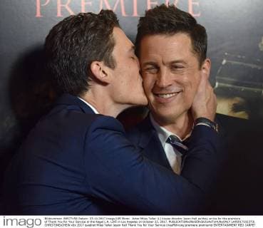 Actor Miles Teller (L) kisses director Jason Hall as they arrive for the premiere of Thank You for Your Service at the Regal L.A. LIVE in Los Angeles on October 23, 2017.  LAP20171023731 CHRISTINExCHEW