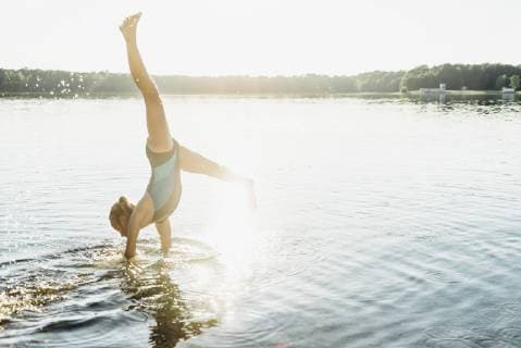 Girl doing cartwheel at lakeshore model released Symbolfoto  MJF02202