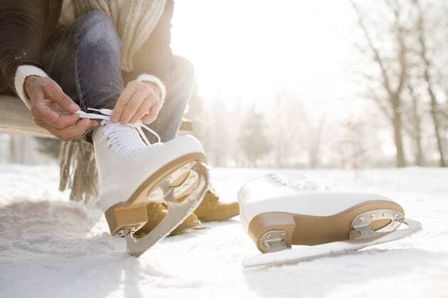 IMAGO Creative, Jahreszeit Winter, Eislaufen Woman sitting on bench in winter landscape putting on ice skates model released Symbolfoto  HAPF02146