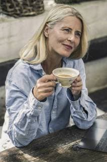 IMAGO Creative: Internationaler Frauenmonat, Gesundheit, Frauen in der Menopause Mature woman sitting on terrace drinking tea model released Symbolfoto property released  RIBF00716