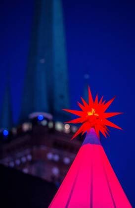 Lübecker Weihnachtsmarkt Ein Weihnachtsstern leuchtet am 24.11.2016 auf dem Weihnachtswunderland an der Obertrave in vor dem St. Petri Kirchturm in Lübeck. Luebeck Schleswig-Holstein Germany