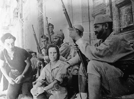 17 year old Anita Royo from Morocco with Moorish soldiers on the Madrid front. She ran away from home in Melilla and stowed away secretly to southern Spain, she is the only woman serving with the rebel forces on the Madrid front and acts as a nurse. 13 August 1937, Madrid Spain Copyright: Topfoto  UnitedArchivesEU057925