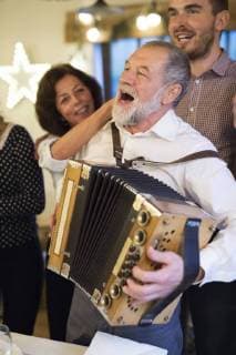 Senior man playing accordion for happy family at Christmas model released Symbolfoto property released  HAPF02216