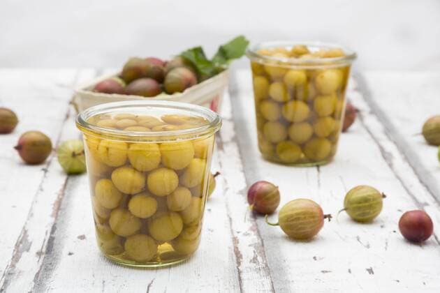 Jar of preserved gooseberries and gooseberries on wood  LVF06293