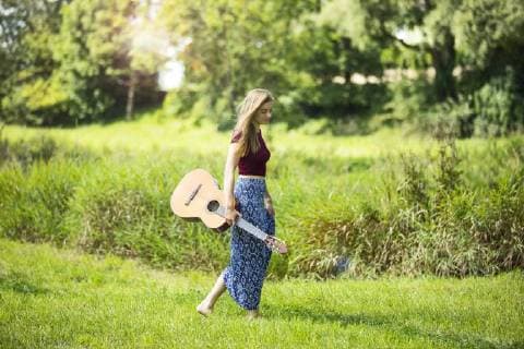 Young woan in nature with guitar model released Symbolfoto  MAEF12428
