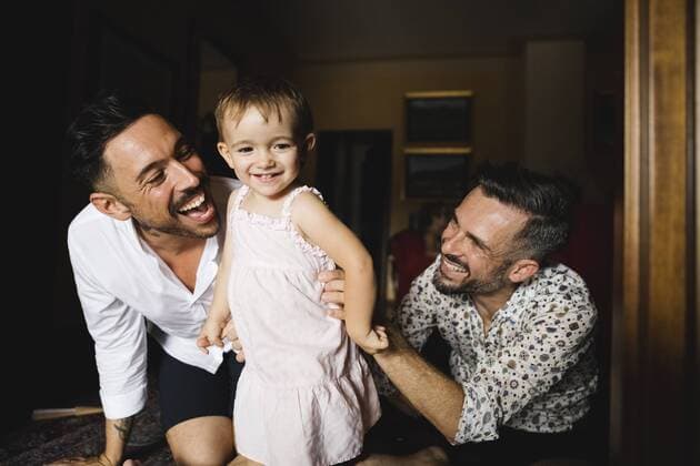 IMAGO Creative: Vaterschaft IMAGO Creative: Pride Month, Juni 2022, Pärchen und Familien Happy gay couple playing with their little daughter at home model released Symbolfoto property released  MRAF00240