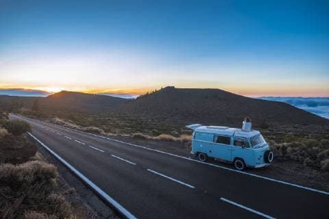 Spain, Tenerife, back view of woman sitting on car roof of van parked at roadside model released Symbolfoto  SIPF01760