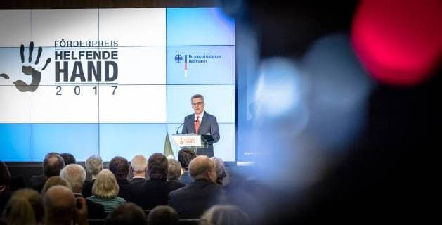 Helfende Hand 2017: Bundesinnenminister Thomas de Maiziere Bundesinnenminister Dr. Thomas de Maiziere verleiht in Berlin den Foerderpreis Helfende Hand 2017 . Mit diesem jaehrlich vergebenen Foerderpreis werden Ideen und Konzepte ausgezeichnet, die das Interesse der Menschen für ein ehrenamtliches Engagement im Bevoelkerungsschutz wecken.