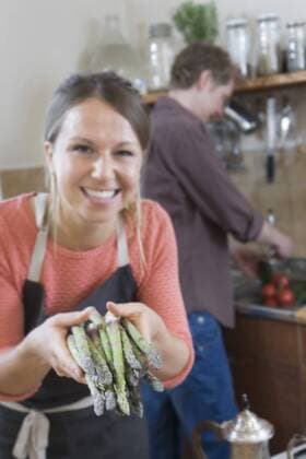 Couple preparing food, woman holding asparagus mit_2003_10943