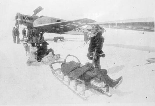 SS Chelyuskin , a Soviet steamship sent out on an expedition to navigate through polar ice along the Northern Maritime Route from Murmansk to Vladivostok , has became ice-bound in Arctic waters during navigation . It was caught in the ice fields in September. After that it drifted in the ice pack before sinking on February 13 , 1934, crushed by the icepacks near Kolyuchin Island in the Chukchi Sea . The crew managed to escape onto the ice and built a makeshift airstrip using only a few spades , ice shovels and two crowbars , which helped in the rescue of the crew . Fifty three men walked over the ice with stores on husky sleds . Photo shows ; One of the rescue planes receiving some of the casulties of the cold on huskie sleds . 1934, Russia Federation Copyright: Topfoto  !ACHTUNG AUFNAHMEDATUM GESCHÄTZT! UnitedArchivesEU038095