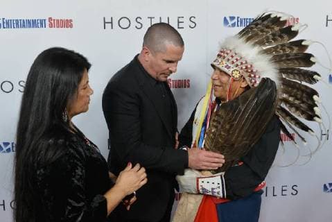 Cast member Christian Bale totes Chief Phillip Whiteman Jr. s eagle feathers as Lunette Two Bulls looks on during the premiere of the motion picture western Hostiles at the Academy of Motion Picture Arts & Sciences in Beverly Hills, California on December 14, 2017. Storyline: In 1892, a legendary Army captain reluctantly agrees to escort a Cheyenne chief and his family through dangerous territory.  LAP2017121408 JIMxRUYMEN