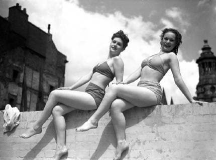 Time to play. Two of the famous Windmill Theatre, London, beauties snatch time off between shows for holiday swim at Holborn Open Air Swimming Pool. Jill Anstey (left) and Beth Ross finds the wall a useful perch for sunbathing. 2 August 1946, London United Kingdom England Copyright: Topfoto  !ACHTUNG AUFNAHMEDATUM GESCHÄTZT! UnitedArchives1379530