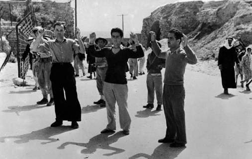 Arab prisoners at Acre in battle for Lebanese border. The Jewish and Lebanese forces now face each other 1,000 yards apart at Ras El Naqura on the Lebanese Frontier in the battle for the border which is the latest development that followed the fall of Acre. Haganah cleared the coastal road from Acre towards the frontier and brought many prisoners back to Acre. Photo shows ; Arab prisoners seen with their hands up as they were taken for interrogation on arrival at Acre . 17 May 1948, ACRE Israel Copyright: Topfoto  !ACHTUNG AUFNAHMEDATUM GESCHÄTZT! UnitedArchives1379557