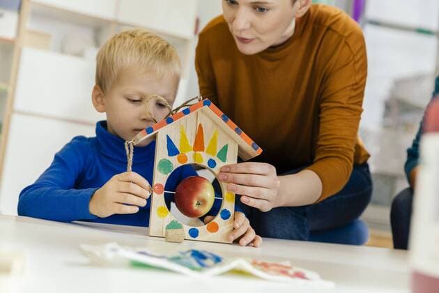 Child and pre-school teacher building a bird table in kindergarten model released Symbolfoto property released  MFF04131