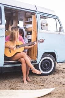 Young couple with guitar and surfboard in van on the beach model released Symbolfoto  SIPF01813