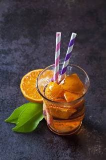 Fruit spritzer of tangerines in a glass with drinking straws  CSF28476