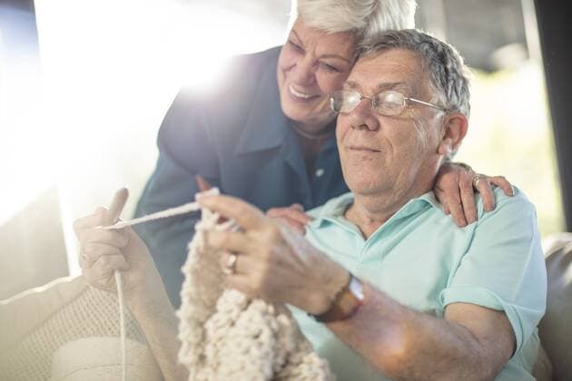 Happy senior couple on couch at home knitting model released Symbolfoto property released  ZEF14776