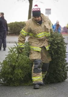 (180107) -- RICHMOND, Jan. 7, 2018 -- A firefighter carries the trees for recycling during the annual Christmas tree chipping event in Richmond, Canada, Jan. 6, 2018. Collected trees will be chipped and recycled for turning them into resources. ) (zcc) CANADA-RICHMOND-CHRISTMAS TREE-CHIPPING LiangxSen 
