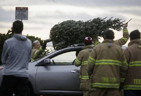 (180107) -- RICHMOND, Jan. 7, 2018 -- Firefighters remove a tree from a car during the annual Christmas tree chipping event in Richmond, Canada, Jan. 6, 2018. Collected trees will be chipped and recycled for turning them into resources. ) (zcc) CANADA-RICHMOND-CHRISTMAS TREE-CHIPPING LiangxSen 