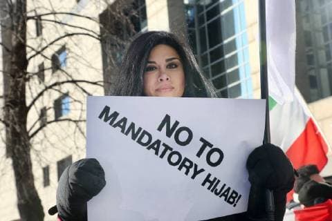 January 6, 2018 - Toronto, Ontario, Canada - Protestor holds a sign saying No to Mandatory Hijab as hundreds of Canadians take part in a protest against the Islamic Republic of Iran in Toronto, Ontario, Canada, on January 06, 2018. Protestors showed their solidarity with anti-government demonstrators in Iran and their support of a national uprising of the Iranian people. Protesters called for a regime change for social justice and freedom and democracy in Iran. There was a also a call that power in Iran be returned to Reza Pahlavi, the former Crown Prince of Iran and the last heir apparent to the defunct throne of the Imperial State of Iran and the current head of the exiled House of Pahlavi. Toronto Canada  - ZUMAn230 20180106_zaa_n230_1130 Copyright: xCreativexTouchxImagingxLtdx