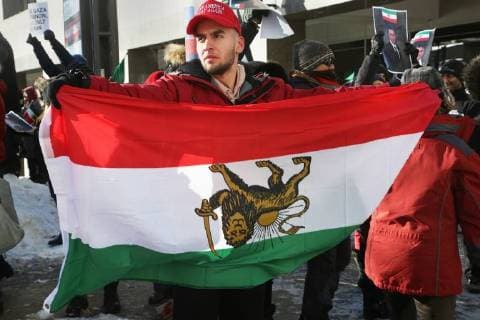 January 6, 2018 - Toronto, Ontario, Canada - Protestor holds an upside down Iranian flag as hundreds of Canadians take part in a protest against the Islamic Republic of Iran in Toronto, Ontario, Canada, on January 06, 2018. Protestors showed their solidarity with anti-government demonstrators in Iran and their support of a national uprising of the Iranian people. Protesters called for a regime change for social justice and freedom and democracy in Iran. There was a also a call that power in Iran be returned to Reza Pahlavi, the former Crown Prince of Iran and the last heir apparent to the defunct throne of the Imperial State of Iran and the current head of the exiled House of Pahlavi. Toronto Canada  - ZUMAn230 20180106_zaa_n230_1148 Copyright: xCreativexTouchxImagingxLtdx