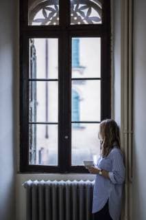 Woman with cup of coffee at home looking out of window model released Symbolfoto property released  GIOF03608