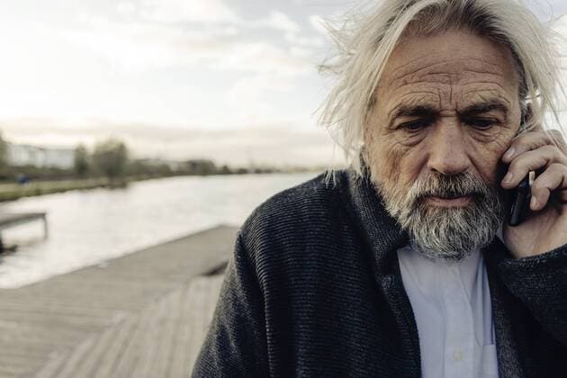 IMAGO Creative: Gesundheit, Demenz Portrait of serious senior man on cell phone at a lake model released Symbolfoto  KNSF03339
