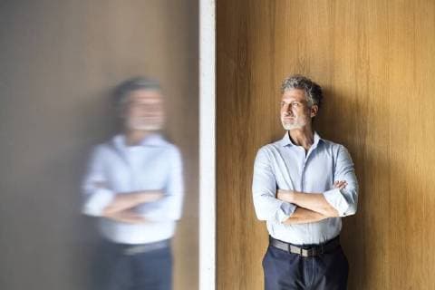 Reflection of mature businessman standing at wooden wall model released Symbolfoto property released  HAPF02569