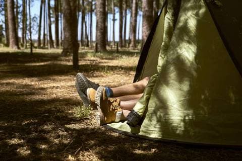 Shoes are sticking out of a tent in forest model released Symbolfoto  SRYF00718