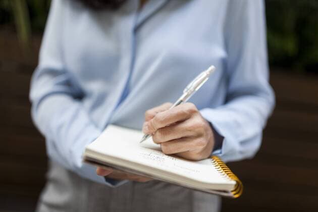 Internationalter Tag der Linkshänder am 13. August Close-up of businesswoman taking notes model released Symbolfoto  VABF01398
