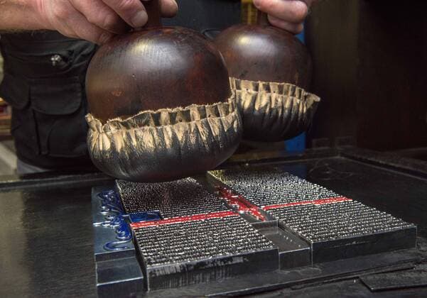 Michael Sobotta vom Johannes-Gutenberg-Museum in Mainz demonstriert am 17.01.2018 in der im Museum rekonstruierten Druckerwerkstatt von Gutenberg wie zu Zeiten Johannes Gutenbergs gedruckt wurde (Foto: mit den Druckballen wurde die Farbe auf die Lettern gegeben). Kaum eine andere Erfindung hat die Welt so sehr veraendert wie die des Mainzer Kaufmannssohns Johannes Gutenberg. Ohne den Buchdruck waeren viele historische Entwicklungen der Neuzeit undenkbar. Die ersten kommerziellen Erfolge erzielte er ausgerechnet mit Ablassbriefen. Im Auftrag der katholischen Kirche produzierte der Mainzer Johannes Gutenberg die beruechtigten Bescheinigungen, die den Kaeufern pauschal Vergebung aller ihrer Suenden versprachen. Zum Einsatz kam eine revolutionaere Technologie, die der Tueftler zuvor in jahrelanger Arbeit ausgefeilt hatte. Gutenberg gilt als E Copyright: epd-bild AndreaxEnderlein EDITORIAL USE ONLY