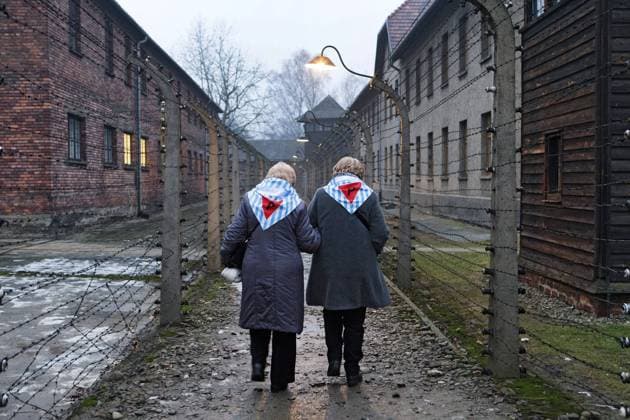 73. Jahrestag der Befreiung von Auschwitz: Zwei Frauen, die das KZ ueberlebt haben, laufen am 27.01.2018 an Baracken des ehemaligen Konzentrationslagers Auschwitz-Birkenau (Polen) mit Stacheldrahtzaeunen entlang. Vor 73 Jahren, am 27.01.1945, wurde das KZ von russischen Truppen befreit. Der Holocaust-Gedenktag fuer die Opfer des Nationalsozialismus wurde 1996 vom damaligen Bundespraesidenten Roman Herzog proklamiert und auf den 27. Januar festgelegt. Die Vereinten Nationen riefen 2005 den 27. Januar als Internationalen Tag des Gedenkens an die Opfer des Holocaust (International Day of Commemoration to honour the victims of the Holocaust) aus. 73. Jahrestag der Befreiung von Auschwitz