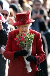 HM Queen Elizabeth II is given bunches of flowers after attending the Sunday morning service at St Peter and St Paul church at West Newton, Norfolk, on February 4, 2018. 