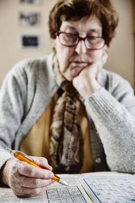 Seniorin sitzt zu Hause am Tisch und löst Rätsel, Sudoku, Kreuzworträtsel, Köln, Nordrhein-Westfalen, Deutschland, Europa Copyright: imageBROKER/JanxTepass ibxjte04634735.jpg