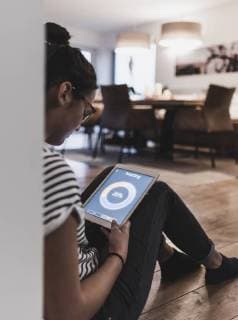 Woman using tablet with heating control function at home model released Symbolfoto property released  UUF12508