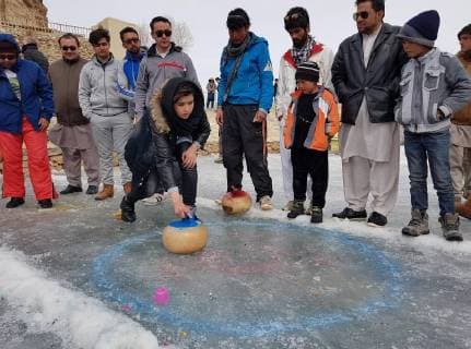 (180225) -- BAMYAN, Feb. 25 -- A woman plays curling during a winter game festival in Bamyan province, Afghanistan, Feb. 23. 2018.) (SP)AFGHANISTAN-BAMYAN-WINTER GAME FESTIVAL LatifxAzimi 