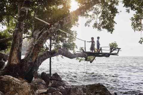 IMAGO Creative, Leben im Bamhaus Thailand, Railay, Rai Leh East Beach, boy and little girl on tree house above the sea model released Symbolfoto  RORF01073