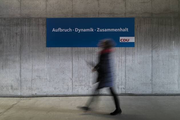 Bilder des Tages Eine Frau laeuft entlang eines Schildes mit der Aufschrift Aufbruch, Dynamik, Zusammenhalt im Rahmen des 30. Parteitags der CDU Deutschland in Berlin, 26.02.2018. Berlin Deutschland