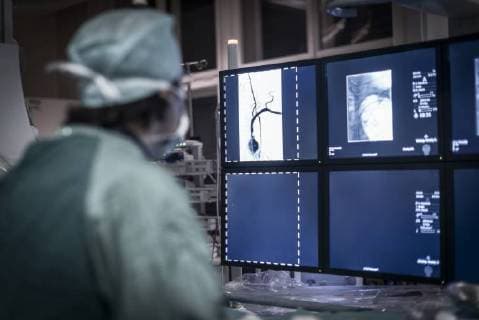 Neuroradiologist in scrubs looking at monitor model released Symbolfoto property released  MWEF00175