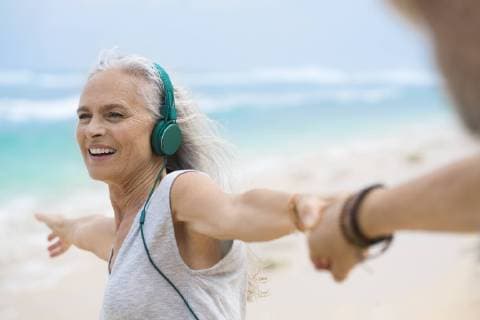 Portrait of beautiful smiling senior woman dancing on beach model released Symbolfoto  SBOF01102