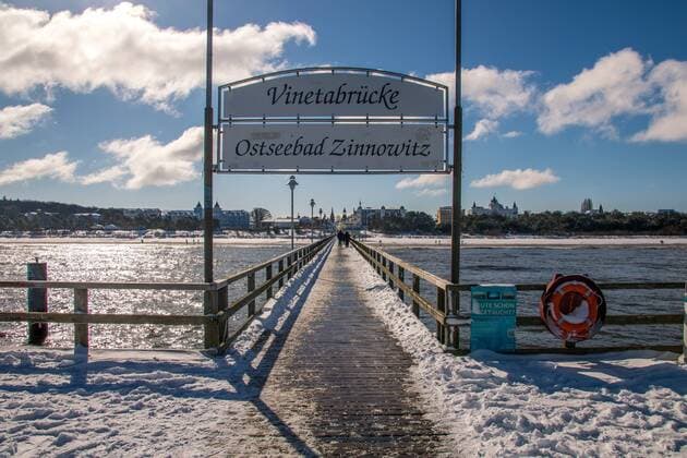 Das Ostseebad Zinnowitz im Winter. Verschneiter Strand und Eis an der Seebrücke.
