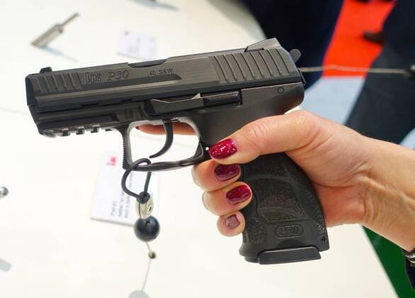 Eine Messebesucherin hält eine Pistole des Modells P30V von Heckler und Koch in der Hand am 09.03.2018 während der Jagd- und Sportwaffenmesse IWA OutdoorClassics in Nürnberg. Auf der IWA präsentieren zwischen dem 9. und 12. März mehr als 1400 Aussteller Jagd- und Sportwaffen, Munition, Messer, Outdoor-Bedarf und Zubehör. ----- A female vistor holds a P30V by Heckler und Koch IWA Outdoor ClassicsMesse in Nürnberg --- IWA fair in Nuremberg