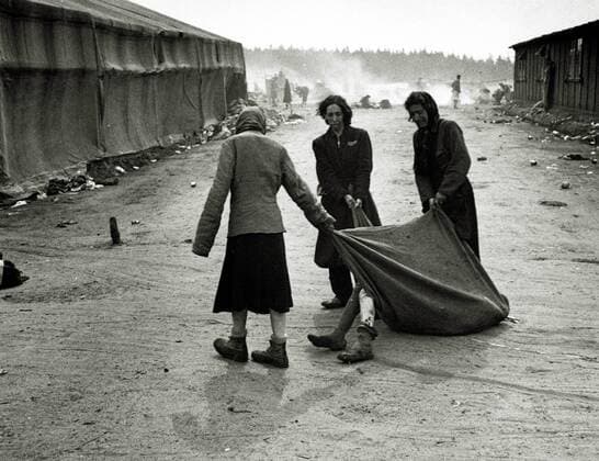 IMAGO History, Zweiter Weltkrieg: 1939 - 1945 KZ Bergen-Belsen Die Insassen ziehen den Körper eines Kranken mit einer Decke nach der Übergabe des Lagers an die Allied 21st Army Group. Im Lager wurden 55.000 Häftlinge - viele mit Typhus und Ruhr - gefunden. 13.000 ehemalige Häftlinge starben nach der Befreiung. Deutschland. Datum: 15. April 1945