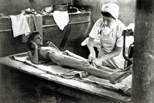 IMAGO History, Zweiter Weltkrieg: 1939 - 1945 KZ Bergen-Belsen Die Behandlung eines Überlebenden nach dem Lager wurde von der Allied 21st Army Group übernommen. Im Lager wurden 55.000 Häftlinge - viele mit Typhus und Ruhr - gefunden. 13.000 ehemalige Häftlinge starben nach der Befreiung. Deutschland. Datum: 15. April 1945