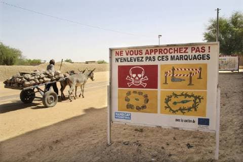 Ein Schild warnt in der Wuestenstadt Timbuktu in Mali am 11.10.2014 vor versteckten Granaten und Minen, die von den Rebellen der Ansar Dine ausgelegt wurden. Seit fast 20 Jahren gilt ein Landminenverbot, 164 Staaten haben es unterzeichnet. Doch Terroristen verschaffen einer der brutalsten Waffen ein Comeback: Sie setzen alte Minen und neue, selbst gebaute Sprengsaetze ein - mit toedlichen Folgen. (Siehe epd-Bericht vom 14.03.18) *** Local Caption *** 00326115 Trotz Landminenverbots werden wieder mehr Sprengsaetze gelegt *** A sign warns in the desert town of Timbuktu in Mali on 11 10 2014 of hidden shells and mines laid by the Ansar Dine rebels A ban on land mines has been in place for nearly 20 years 164 states have signed it But terrorists make one of the most brutal weapons a comeback you put old mines and new self-made explosives with Copyright: epd-bild BettinaxRuehl EDITORIAL USE ONLY