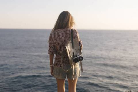 Indonesia, Bali, Lembongan island, young woman with camera at ocean coastline model released Symbolfoto  KNTF01005