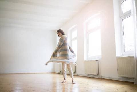 IMAGO Creative: Internationaler Frauenmonat, Gesundheit, Frauen in der Menopause Happy mature woman standing in empty room in sunlight model released Symbolfoto property released  MOEF00777