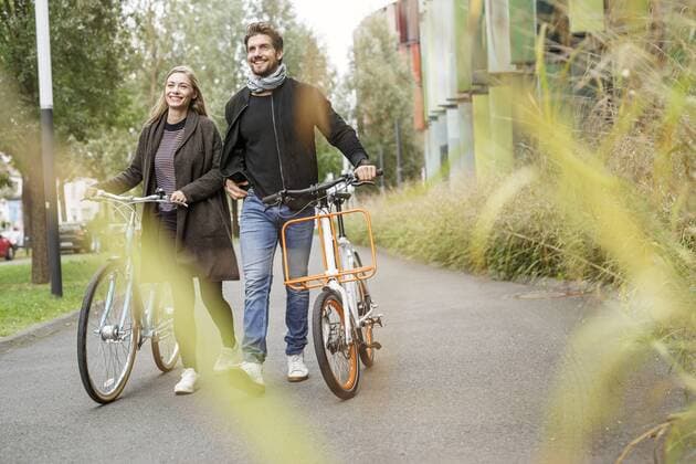 Smiling couple walking with bicycles on a lane model released Symbolfoto  PESF00914